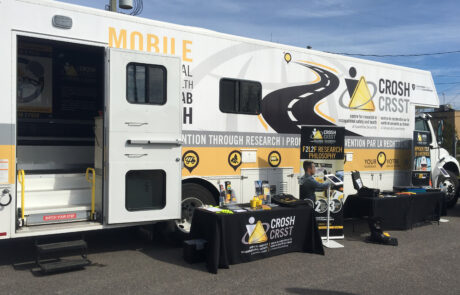 CROSH Mobile Research Lab (M-CROSH) with door open and tables with safety information set-up outside