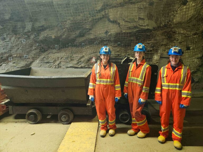 Three CROSH student members wearing mining PPE in a mine drift