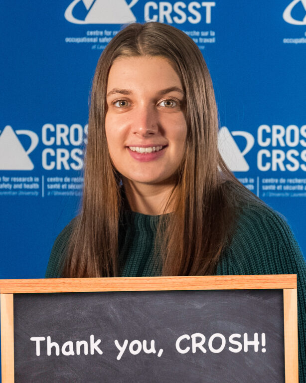 CROSH student member and award winner Janika Lapp with chalkboard that reads "Thank you, CROSH!"